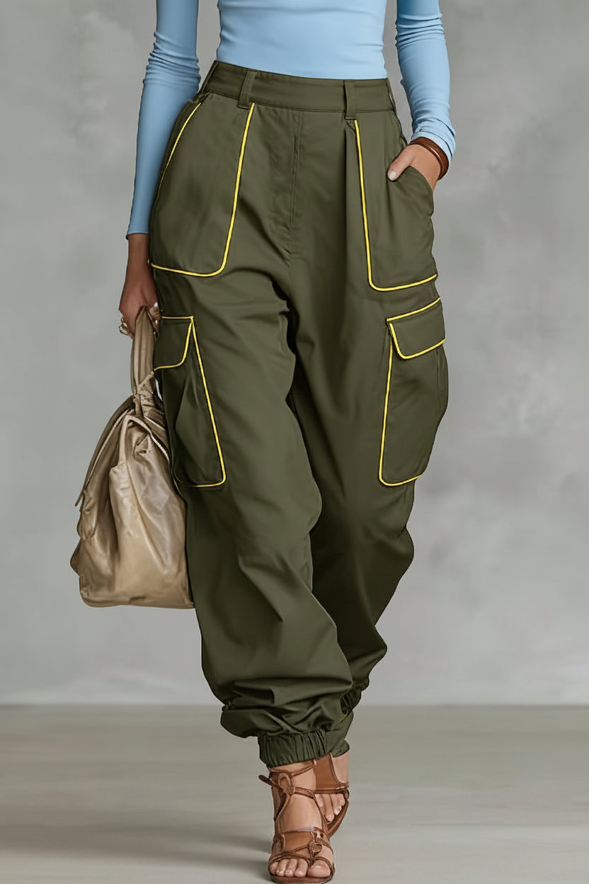 A woman wearing olive green cargo pants with bright yellow contrast piping, multiple utility pockets, and a tapered elastic ankle cuff.