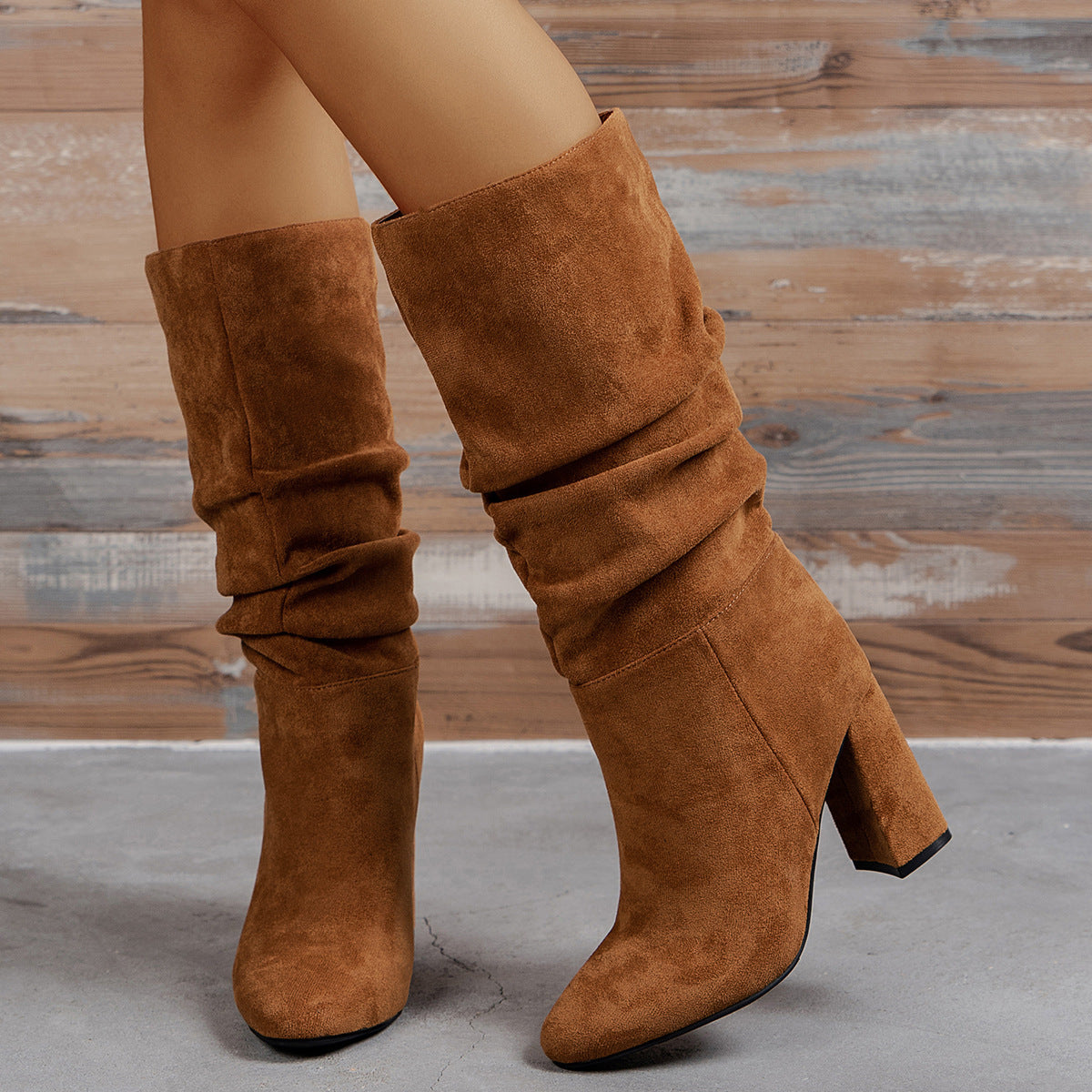 Model wearing brown suede-look slip-on high heel boots with a slouchy shaft design.