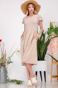 A beige and cream polka dot midi dress with graceful flutter sleeves