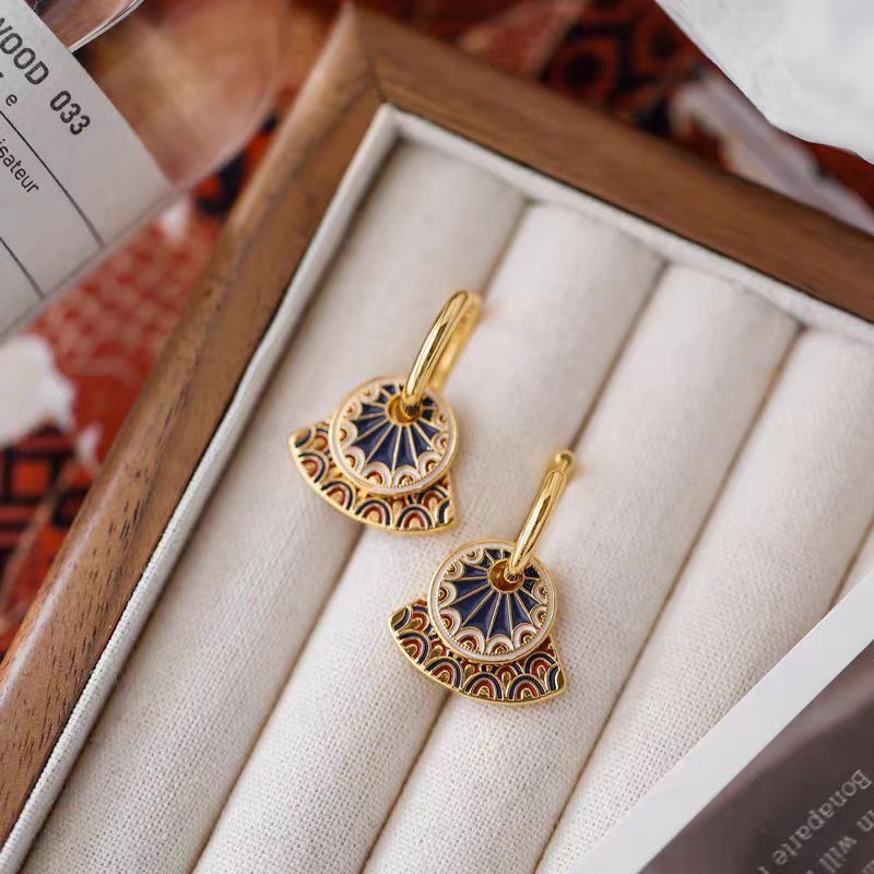 Vintage fan-shaped ear clips with painted details in gold, blue, red, and white