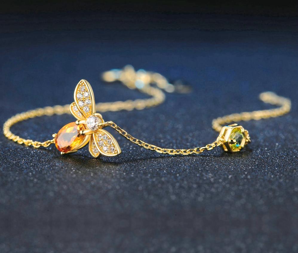 Bee charm bracelet featuring white pearls and 14k gold plated accents