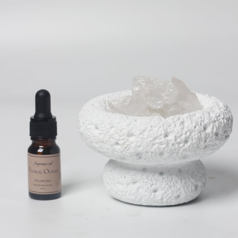 White Moon stone bowl diffuser with Floral Ocean fragrance oil bottle on a white background