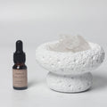 White Moon stone bowl diffuser with Floral Ocean fragrance oil bottle on a white background