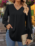 Woman wearing a V-neck blouse with flounce sleeves and ruffled detailing.