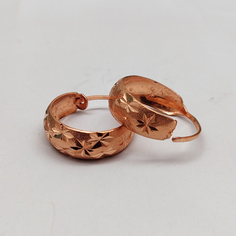 Close-up of retro ethnic-style U-shaped copper hoop earrings with textured finish