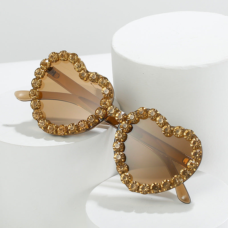 Peach heart-shaped sunglasses adorned with sparkling rhinestones in a Y2K style