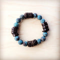 Natural American turquoise and brown wood beaded stretch bracelet on a plain background