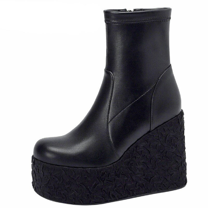 Pair of women's black punk platform wedge ankle boots with textured soles and zipper detail