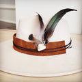 Clip-on hat band with olive feathers and white turquoise stone, shown on a neutral felt hat.