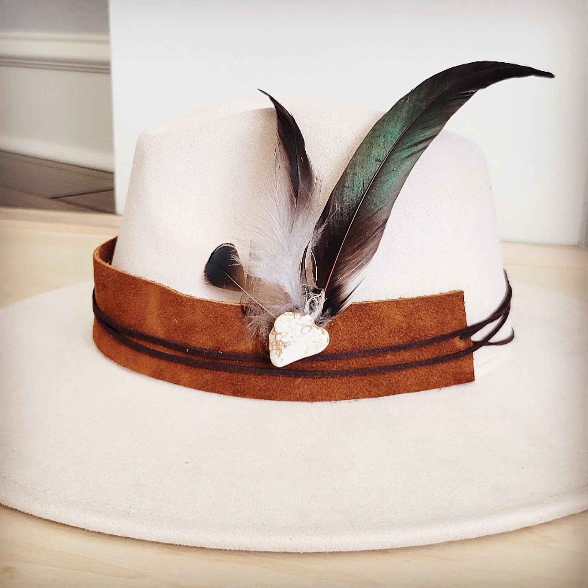 Clip-on hat band with olive feathers and white turquoise stone, shown on a neutral felt hat.