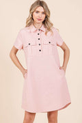 Close up of a collared short sleeve shirt dress featuring button detailing.