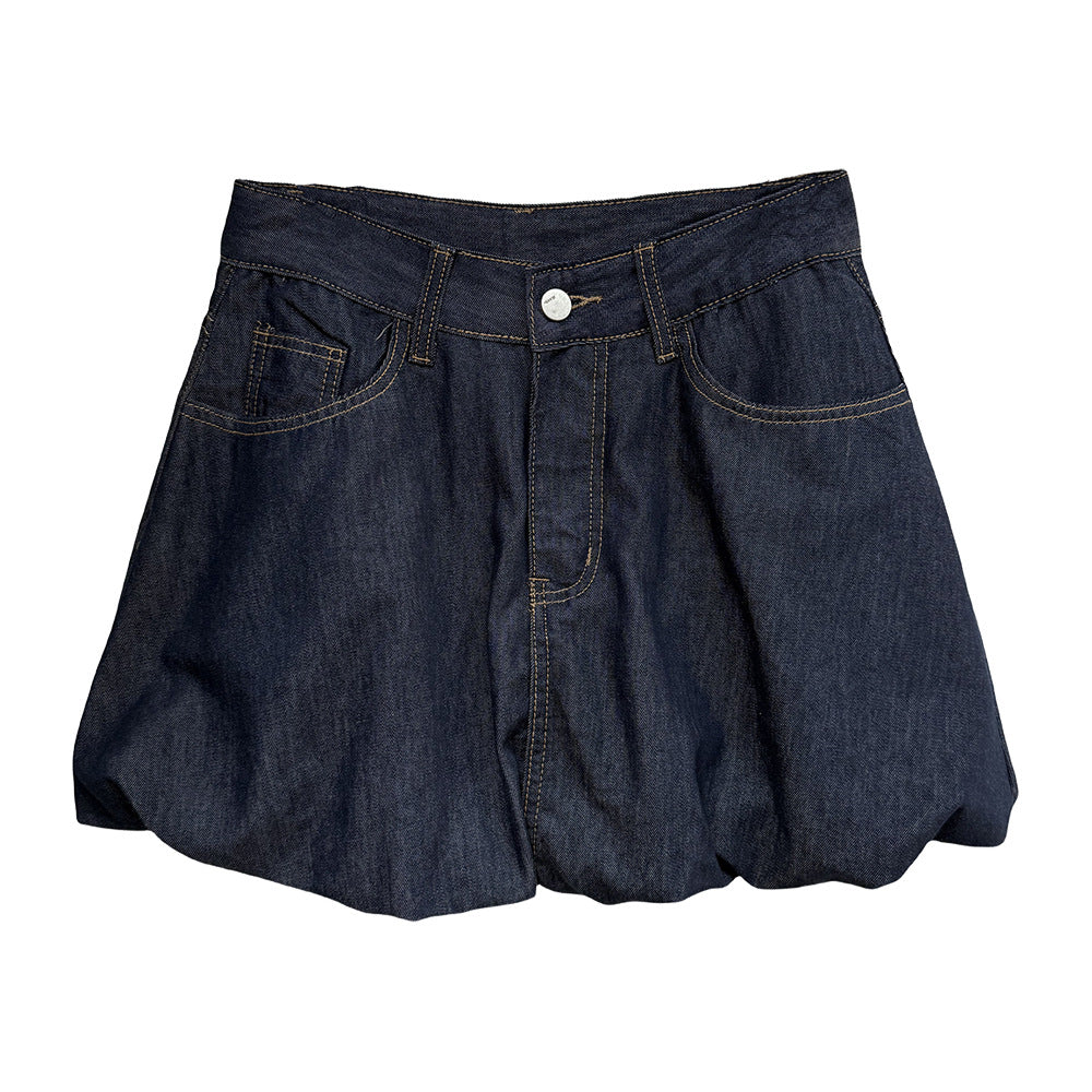 A female model wearing a dark wash denim bubble skirt, showcasing its unique silhouette and retro style.