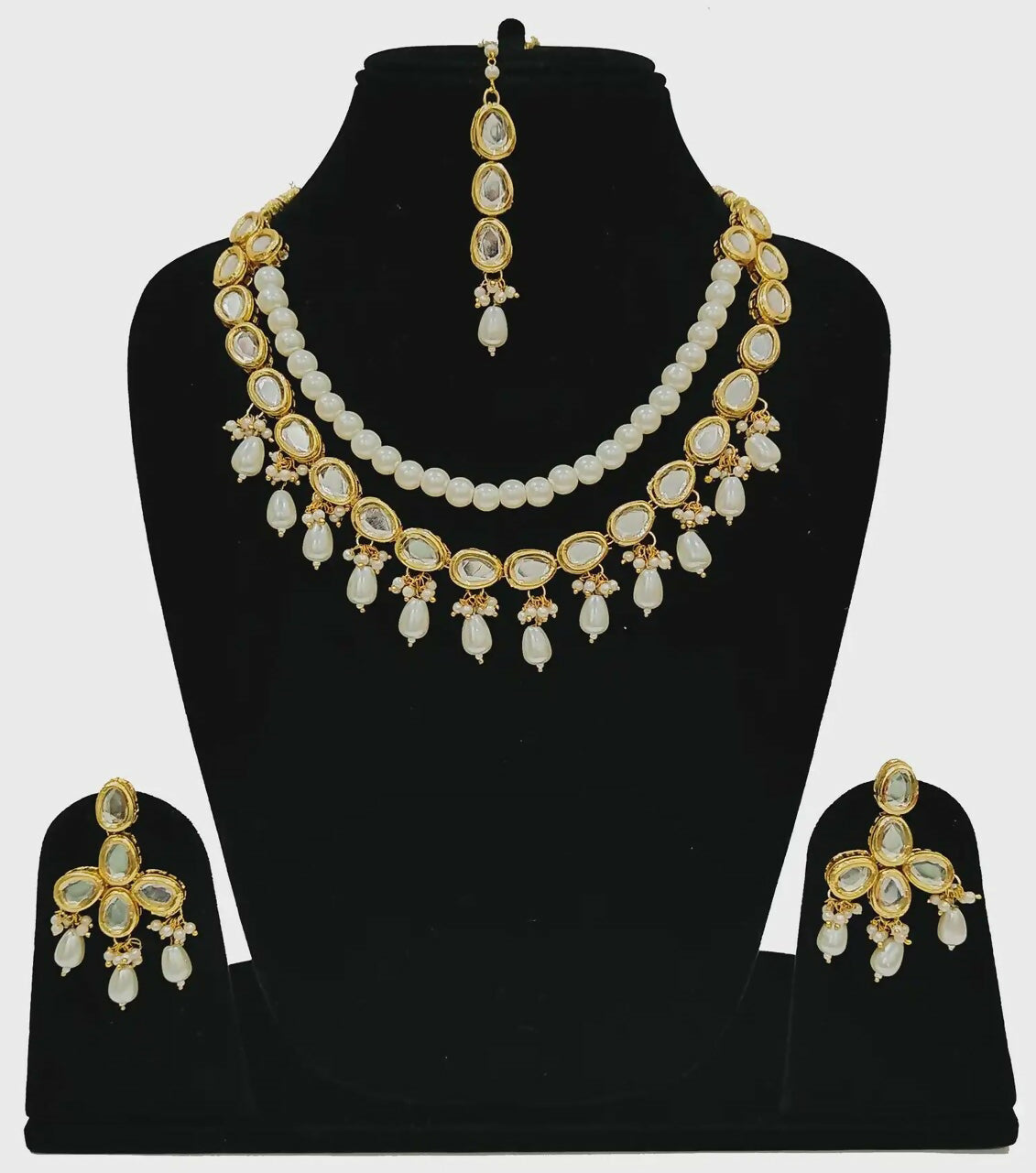 Luxury gold plated Kundan set with hand-set stone accents on a display