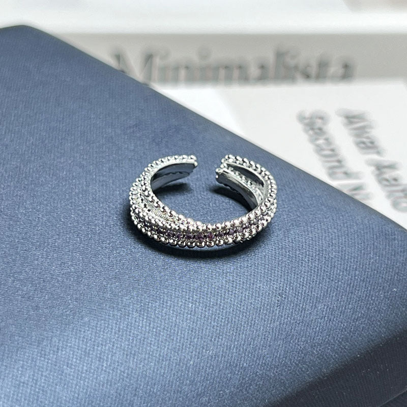 Adjustable open ring featuring purple fire rhinestones in a modern designer style.