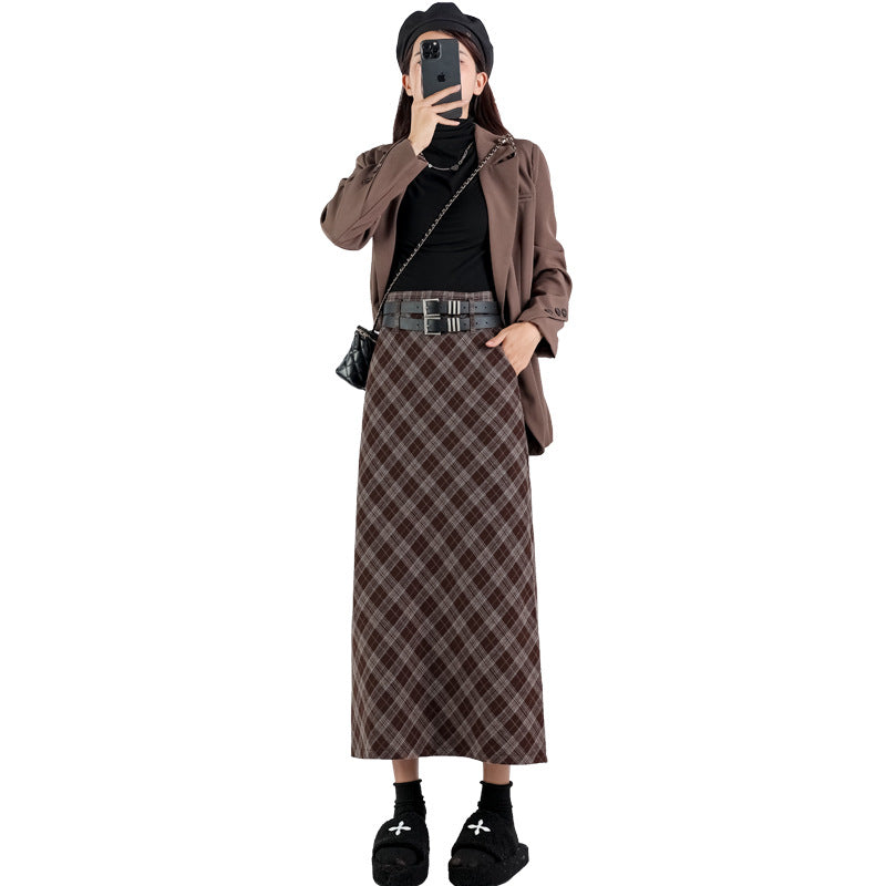 Model wearing a high-waisted plaid A-line midi skirt with a side slit, showcasing both brown and black/grey plaid patterns, styled for a modern college look.