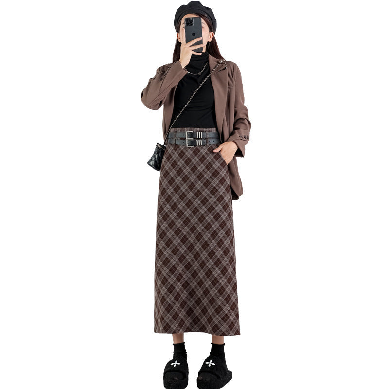 Model wearing a high-waisted plaid A-line midi skirt with a side slit, showcasing both brown and black/grey plaid patterns, styled for a modern college look.