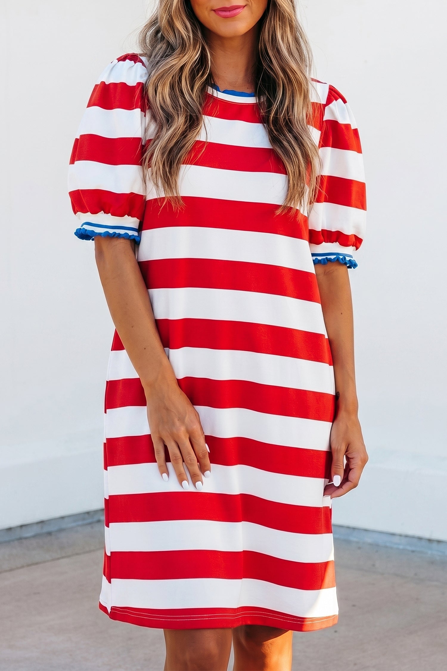 Model wearing a red, white, and blue striped shift mini dress with ruffled sleeves.
