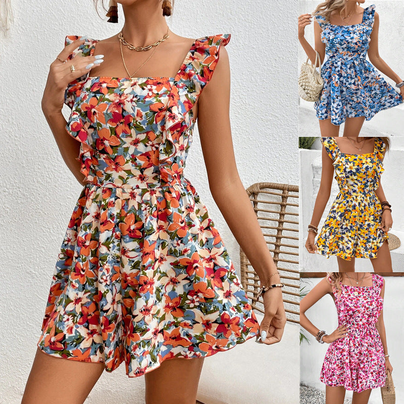 A woman wearing a vibrant floral printed sleeveless romper with ruffled straps and a square neckline.