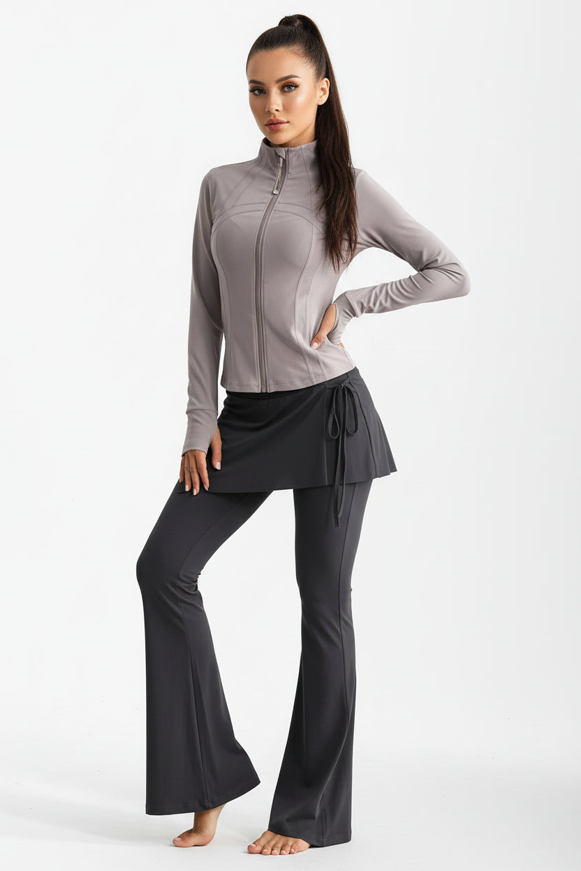 Model wearing a grey long sleeve zip-up athletic top with black skirted leggings