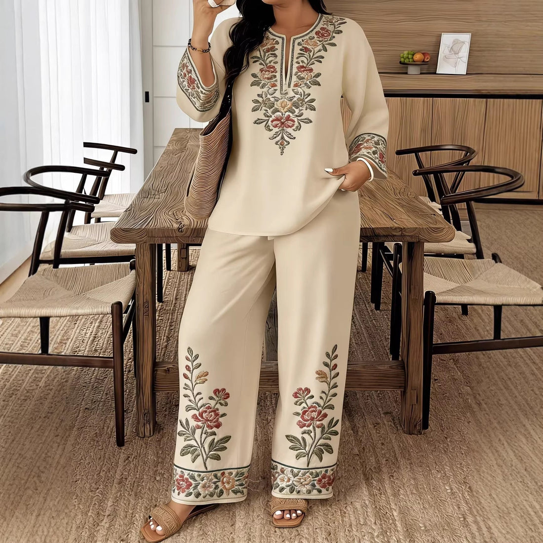 Model wearing a women's ethnic two-piece set with vibrant floral embroidery on a long sleeve shirt and matching wide-leg cropped pants.