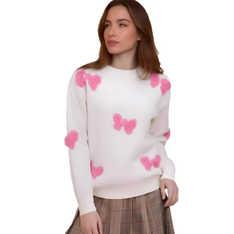 Woman wearing a white long sleeve sweater with pink fuzzy butterfly embroidery details