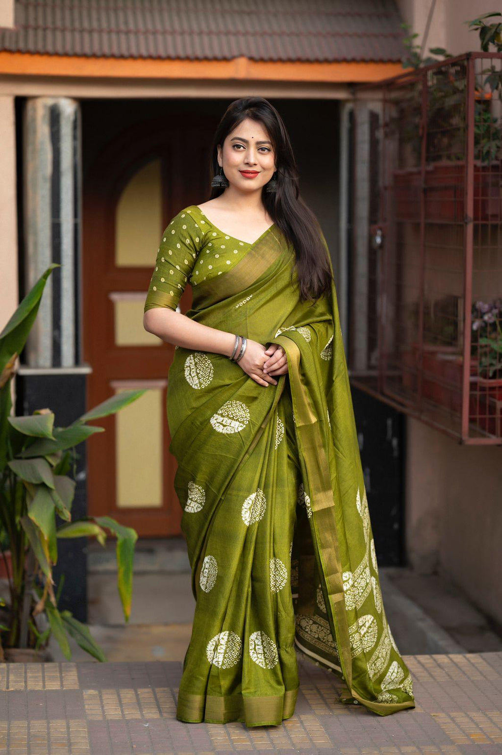 Mehndi green cotton crepe saree with abstract batik print and traditional zari pattu border.