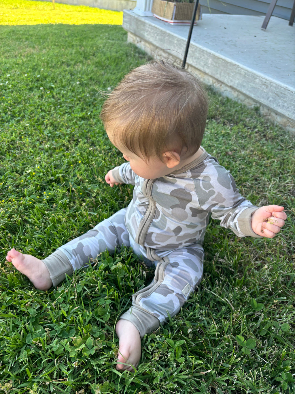 Modern camo knit baby zippy in beige, olive green, and taupe featuring a double zipper.