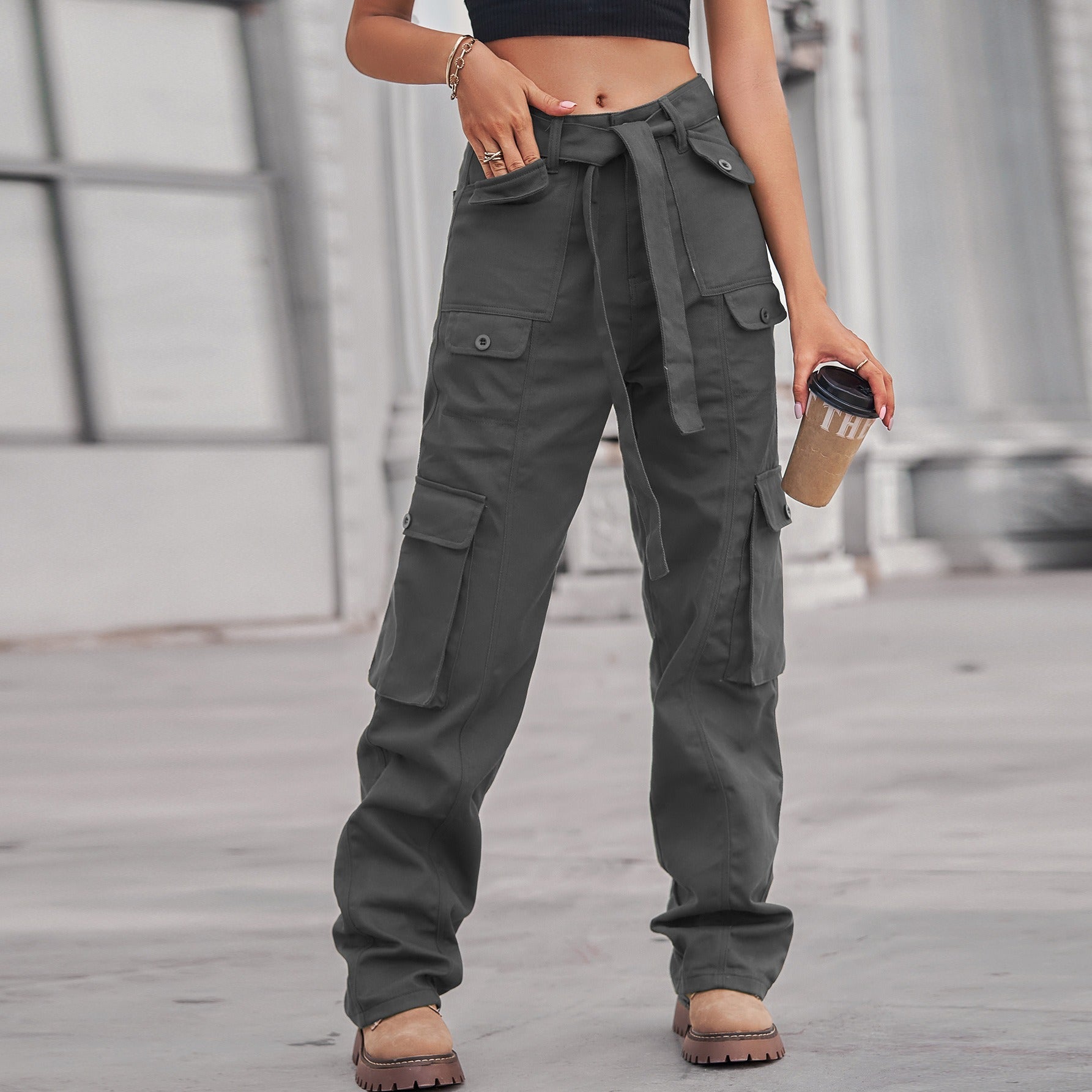 Model wearing dark grey washed denim cargo pants with multiple pockets and a tie waist, styled for a casual Harajuku look.
