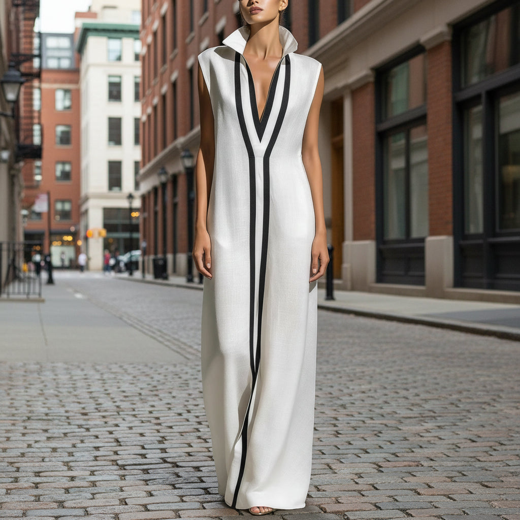 A woman wearing a white sleeveless maxi dress with black color-block vertical stripes and a v-neck collar.