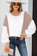Back view of a woman wearing a Zyla oversized colorblock sweatshirt with white and brown stripes and contrast stitching details.