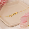 Minimalist Vera Lux gold-tone name bar bracelet featuring a hollow heart accent on a delicate chain