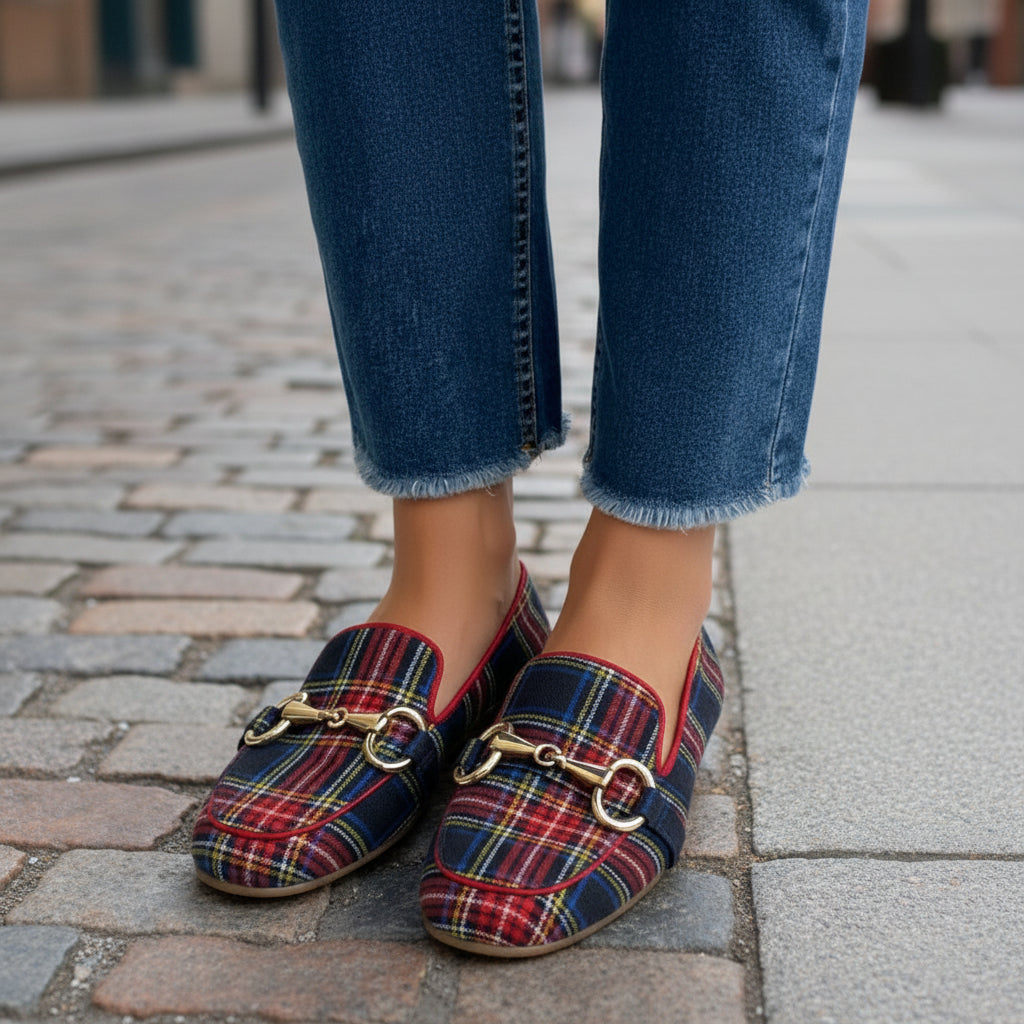 Woman wearing red and blue plaid square toe loafers with a gold buckle detail and cropped jeans.