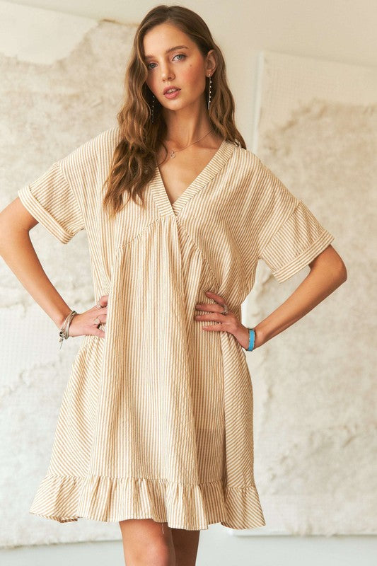 A beige and white striped babydoll dress with a v-neck and ruffled hem.