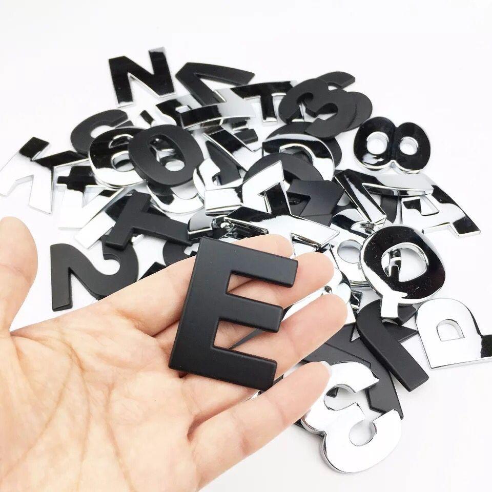 Close up of 3D silver metal alphabet letter stickers applied to a car body for custom exterior trim