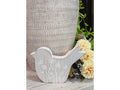 Small wooden bird figurine with a whitewashed rustic finish and white floral details sitting on a wooden surface.