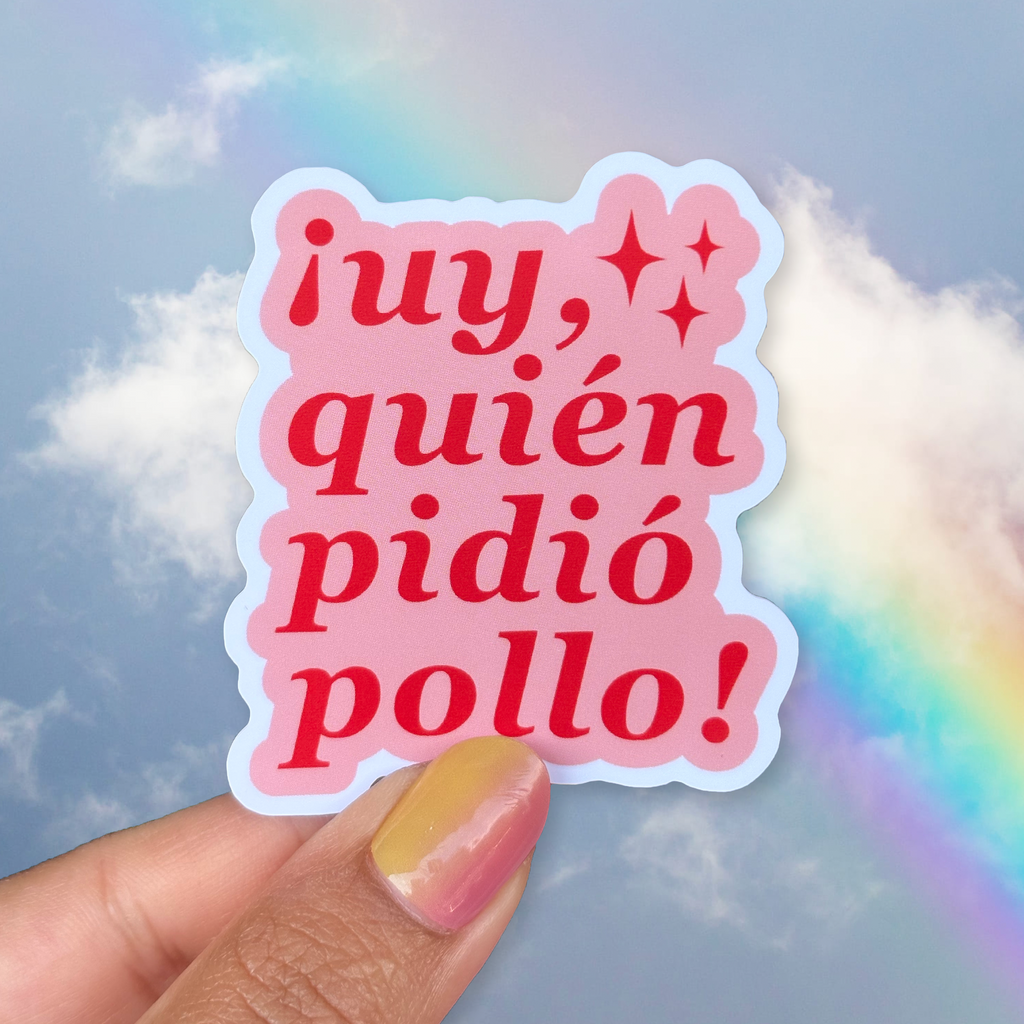 Sticker with Spanish text held by a hand against a colorful sky background