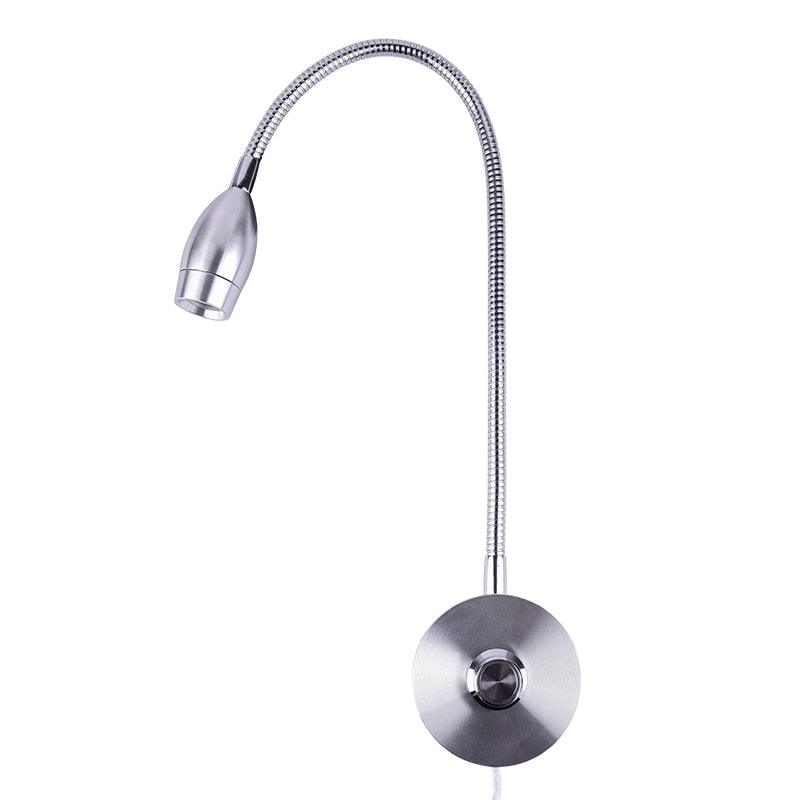 Slim silver modern LED wall reading sconce installed beside a contemporary bed.