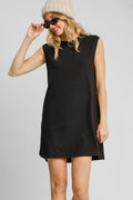 Woman wearing a minimalist black sleeveless mini dress with a high-low curved hem