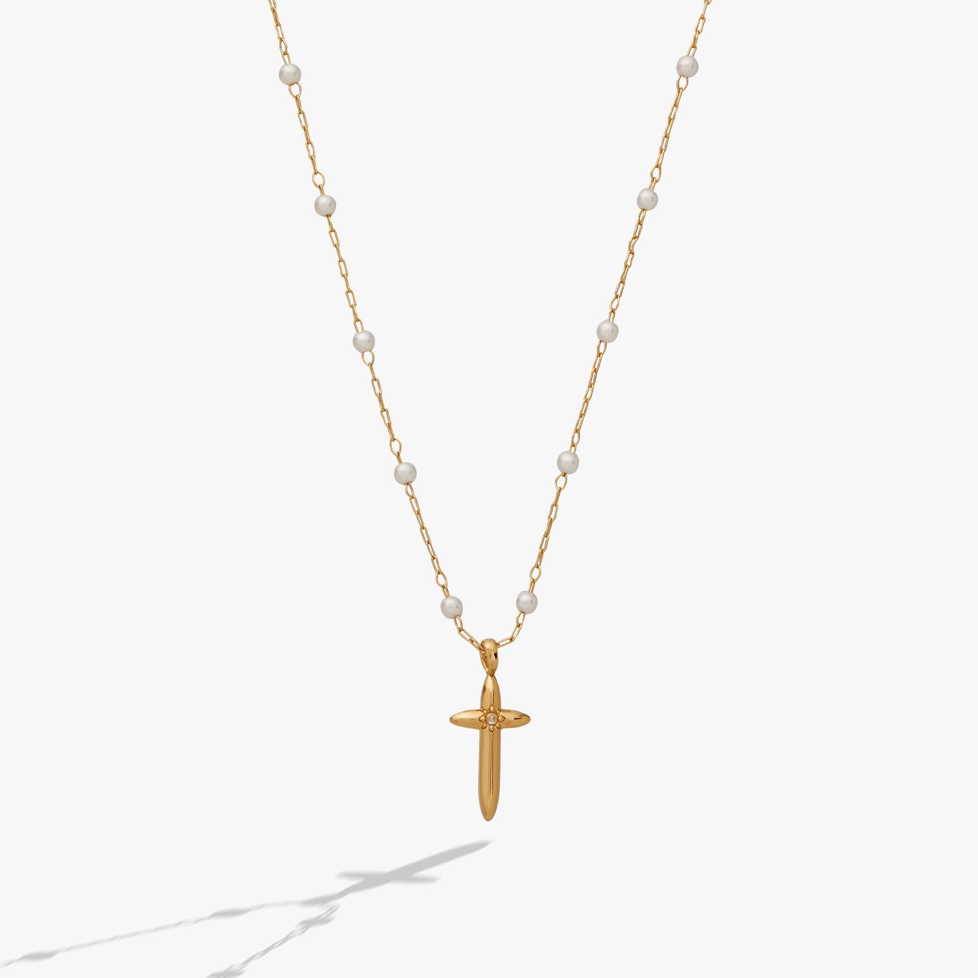 Gold-plated cross pendant with white pearl rosary beads on a delicate chain