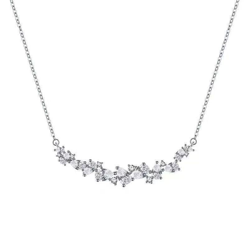 Close up of 999 Sterling Silver smile bar necklace featuring sparkling CZ cluster stones