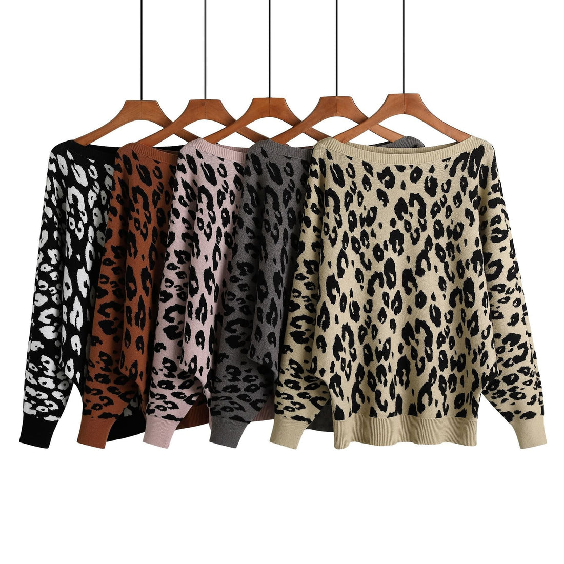 Five women's leopard print sweaters in black and white, brown, pink, grey, and beige, all with a slash-neck design and long bat sleeves, displayed on hangers against a white background.