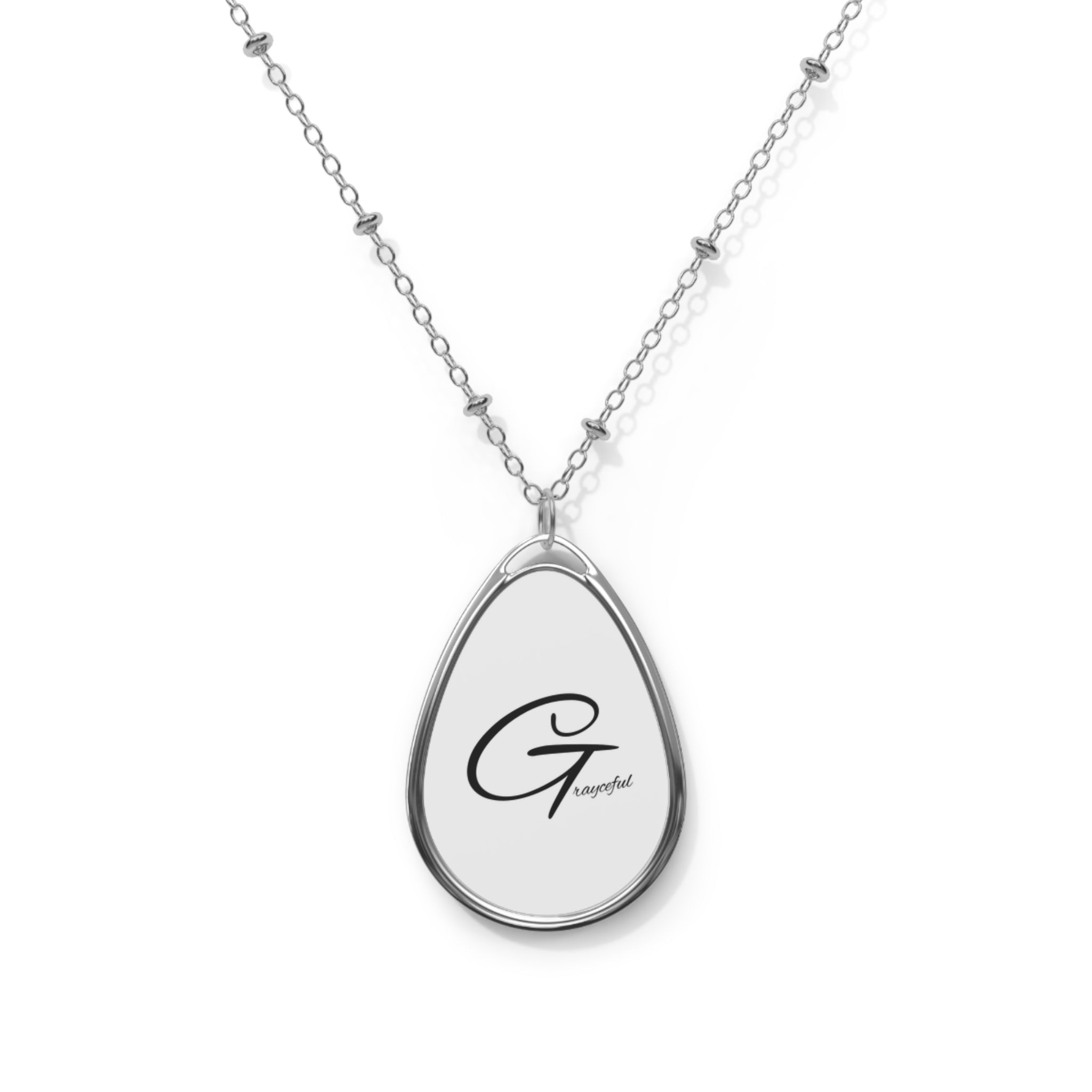 Modern oval pendant necklace in polished silver with a white center on a cable chain