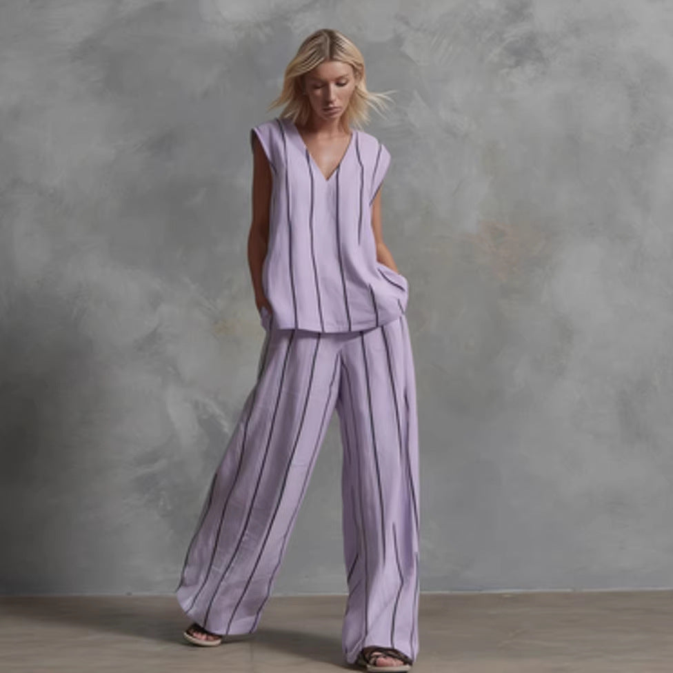 A woman wearing a two-piece matching set with a v-neck sleeveless top and wide-leg trousers featuring a vertical stripe pattern.