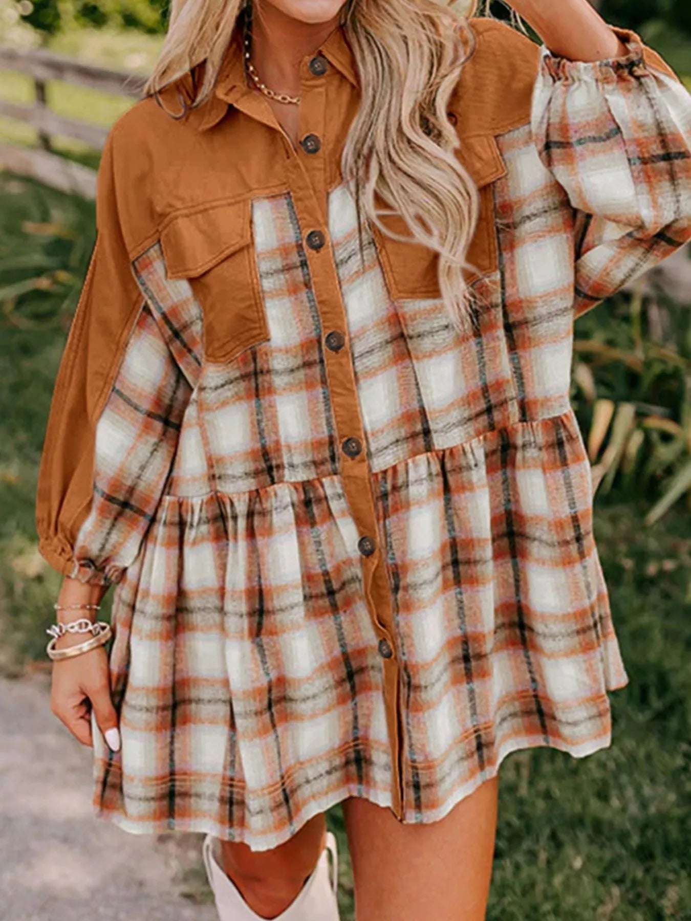 A woman wearing a plaid button-front mini dress with tan solid panels and chest pockets, paired with boots.