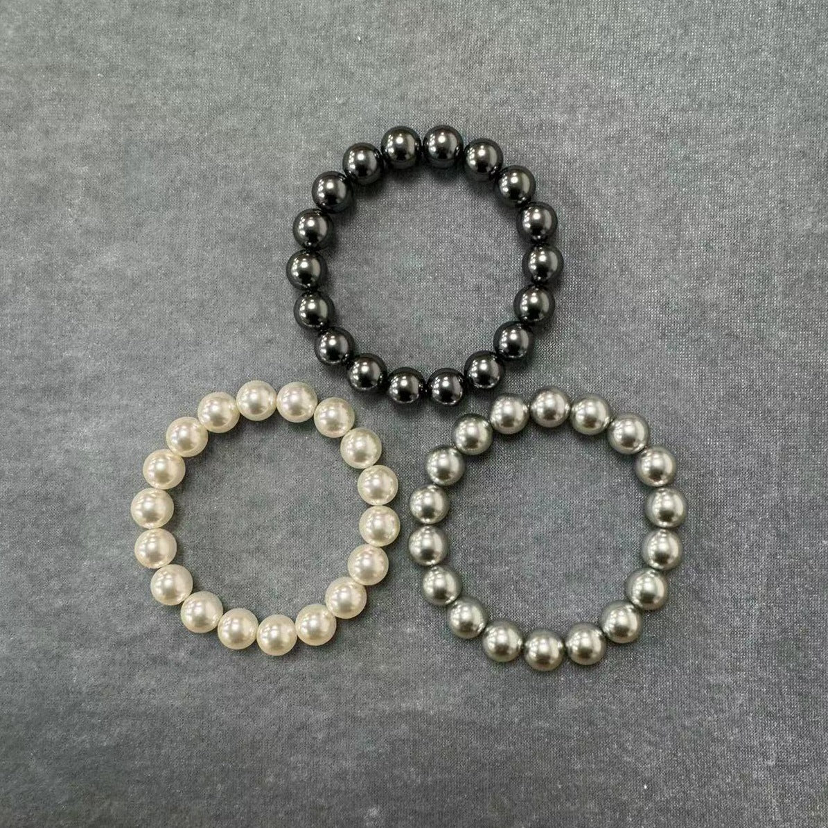Three-color pearl crystal elastic bracelet for women on a white background