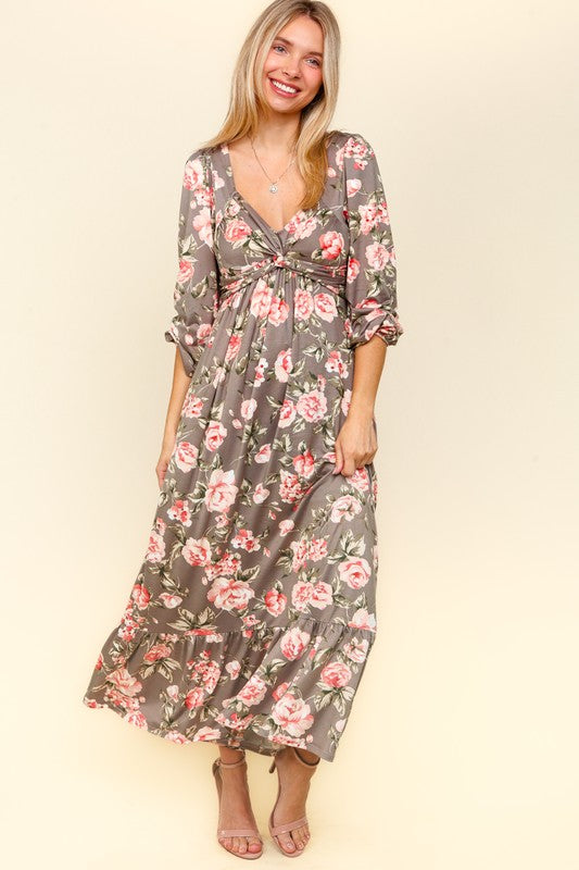 A feminine floral printed dress with a twisted waist detail and a ruffled hem