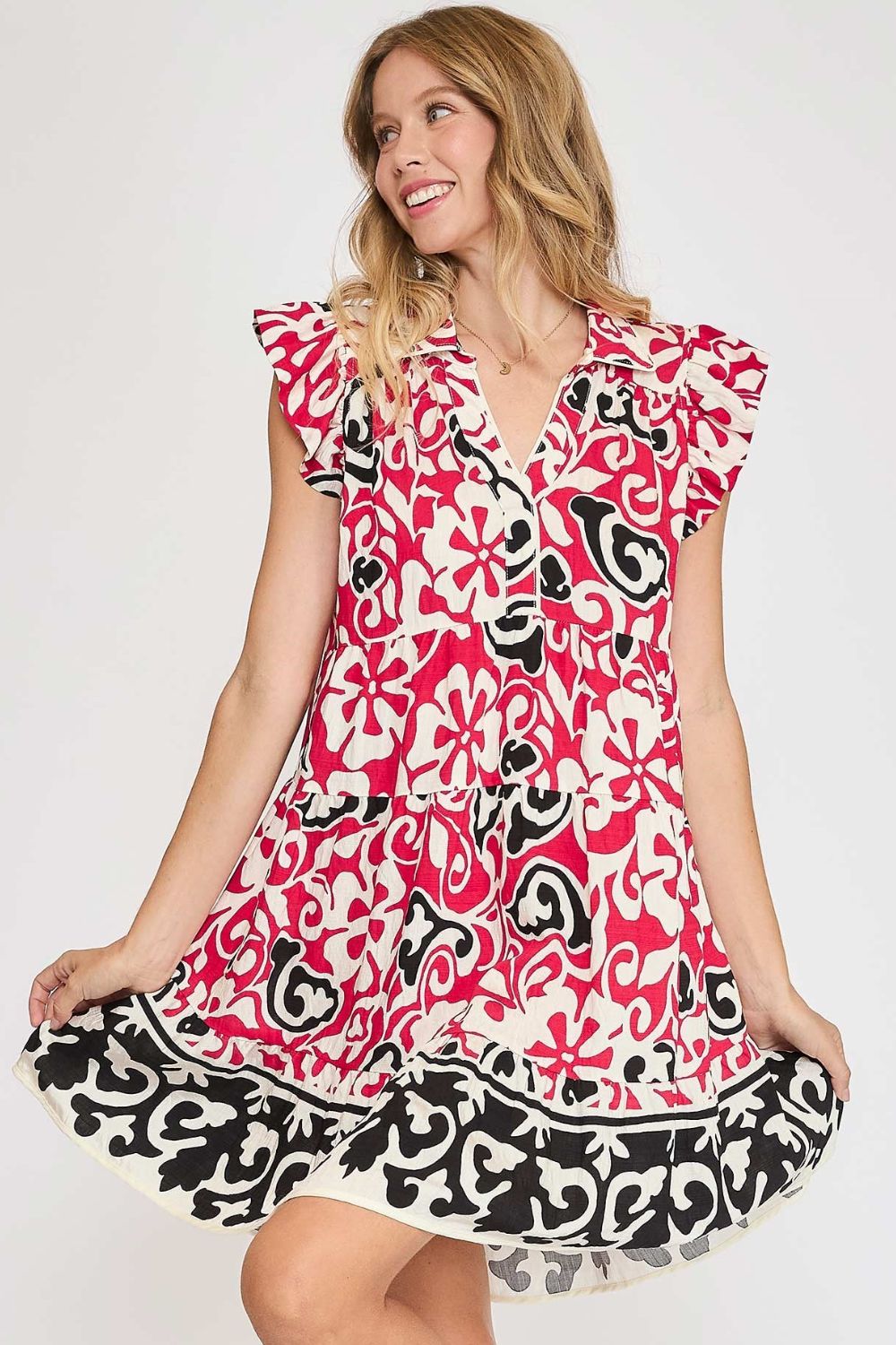 A bohemian style floral print cotton dress with ruffled cap sleeves and a tiered skirt.