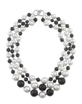 Three strand necklace featuring alternating white round shell pearls and faceted black crystals with a silver-tone clasp.