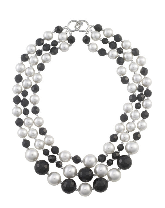 Three strand necklace featuring alternating white round shell pearls and faceted black crystals with a silver-tone clasp.