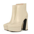 Women's leather platform ankle boots with pointed toe and thick block heel in black and cream.